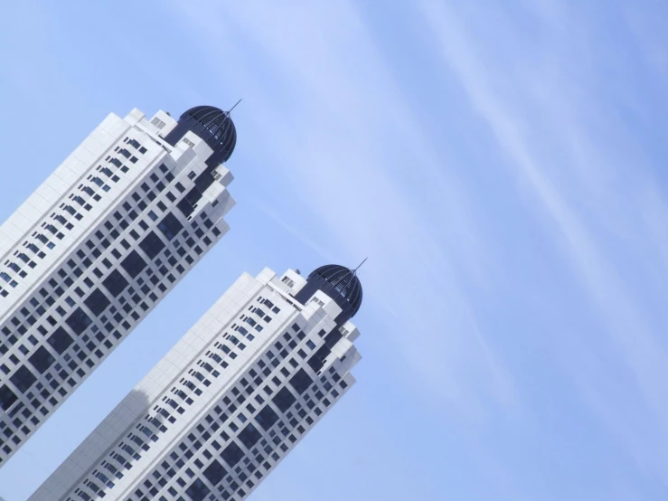 two buildings stand in front of a clear sky