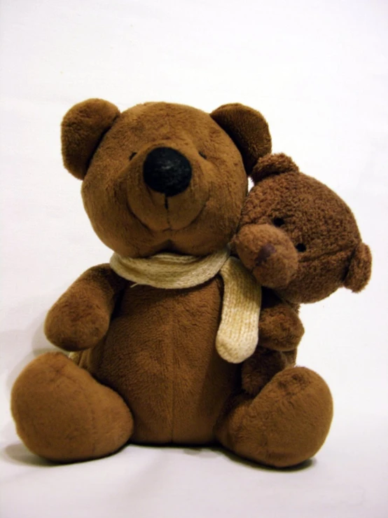 a small brown teddy bear with a scarf around it's neck