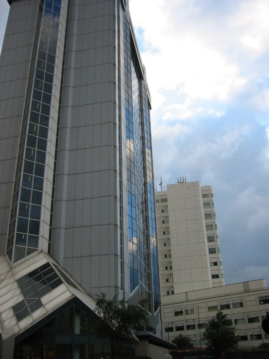 tall building with a large circular window in front of cloudy skies