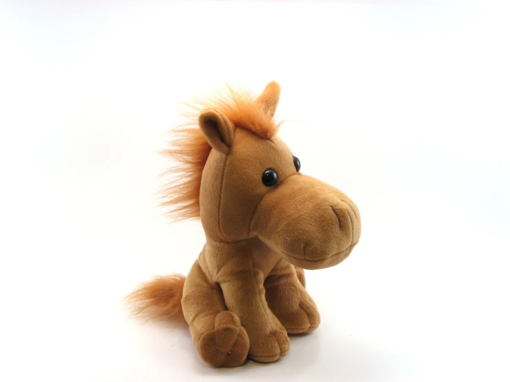 a stuffed pony sitting up on the ground