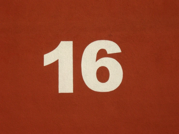 a close up of a number six on a red surface