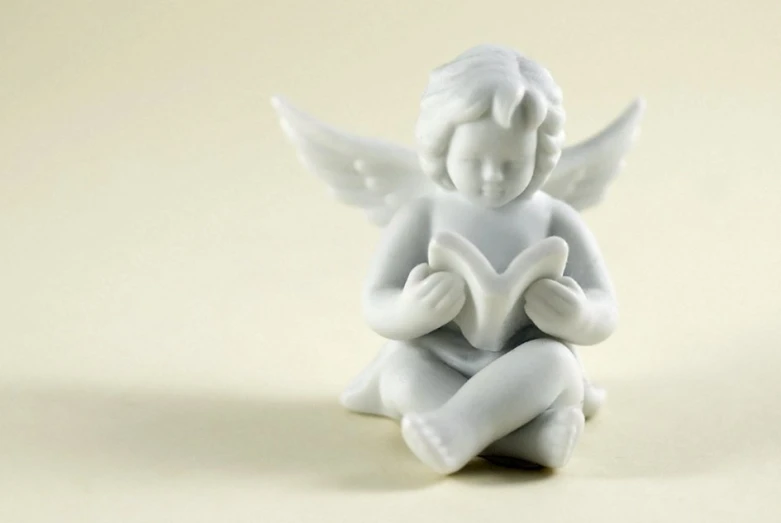 a little ceramic figurine sits on the floor with her hands in their hearts