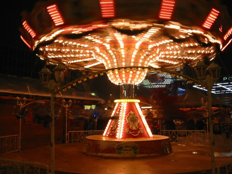 the carousel is lit up at night as it sits on the ground