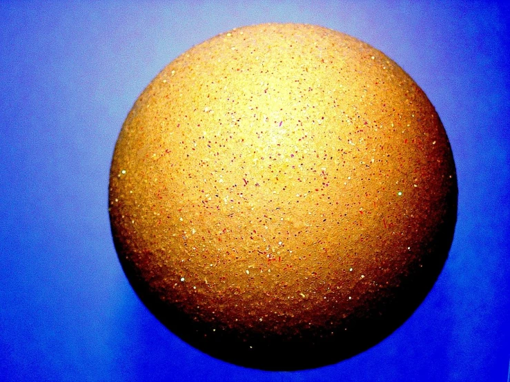 a yellow ball is shown against a blue background