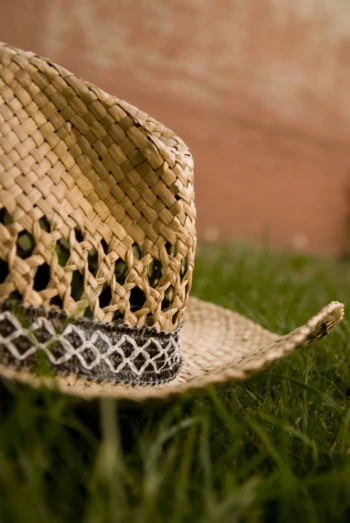 a straw hat laying in the grass near a building