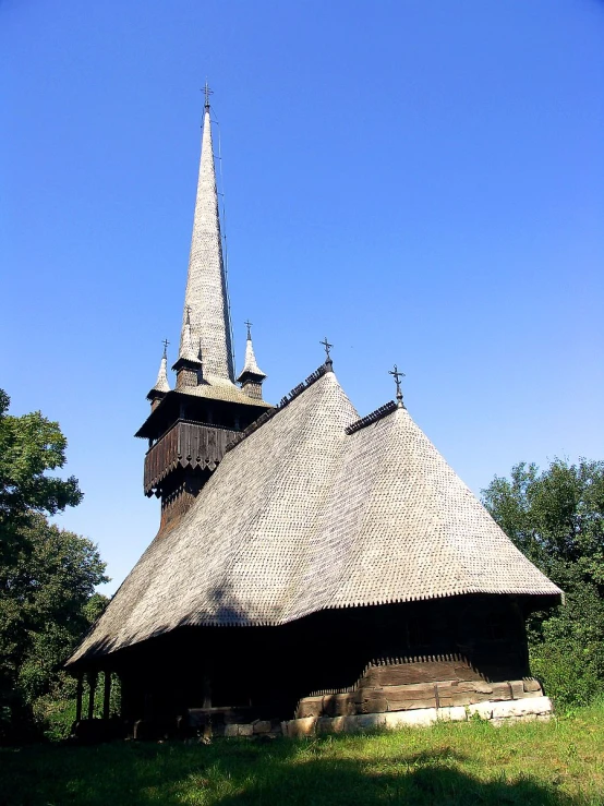 an old black building with a wooden cross