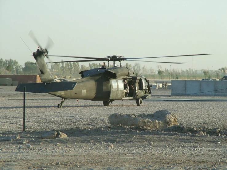 an air force helicopter on the ground with multiple military buildings in the background