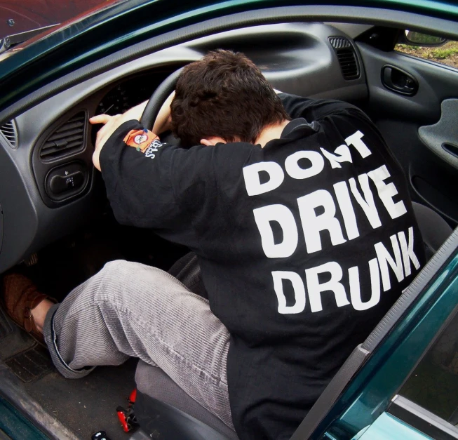 a person wearing a t - shirt with the words don't drive drunk in it