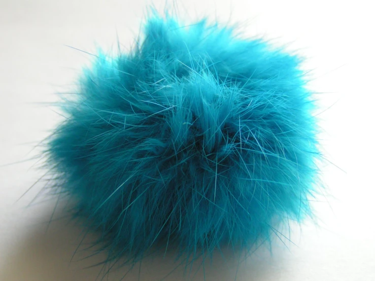 a fluffy, blue furry ball that is slightly attached to the ground