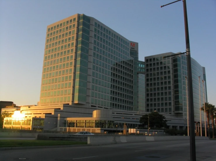 two large buildings are seen in the evening