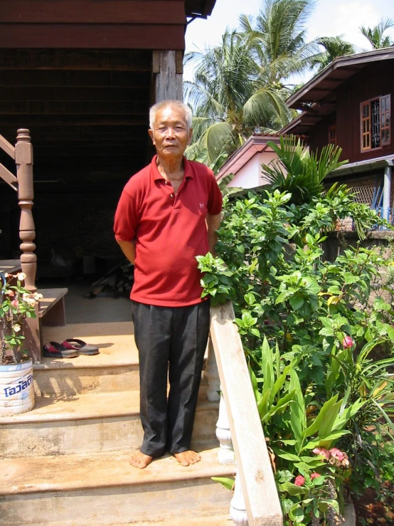 a man in a red shirt standing on stairs