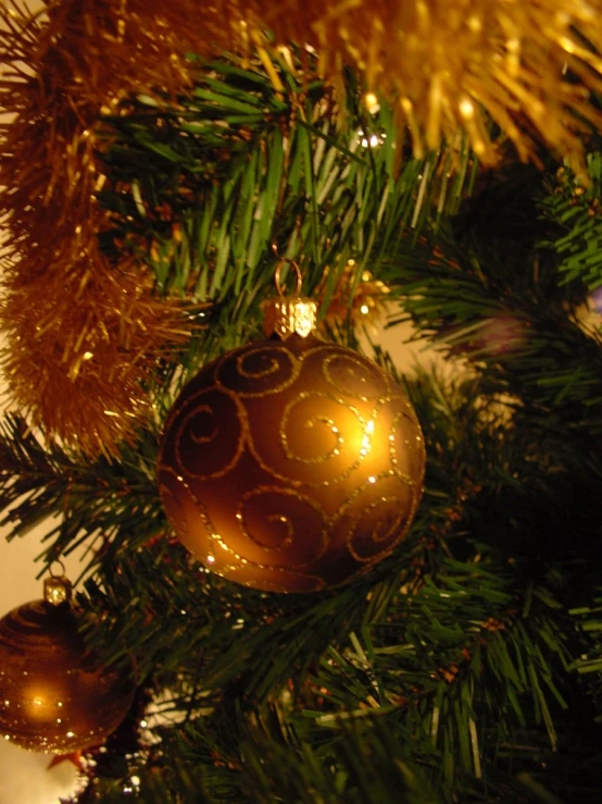 a gold colored christmas ornament is seen on the tree