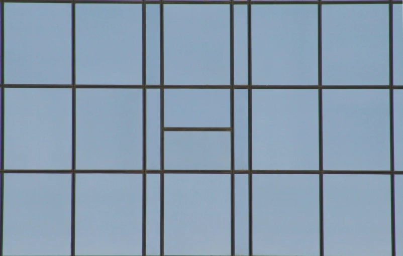 an airplane flying by through a metal window pane