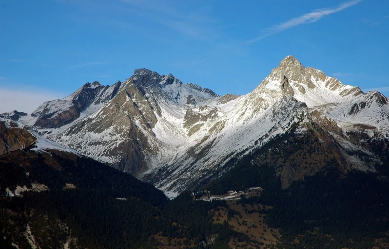 some mountains that are standing up against a blue sky