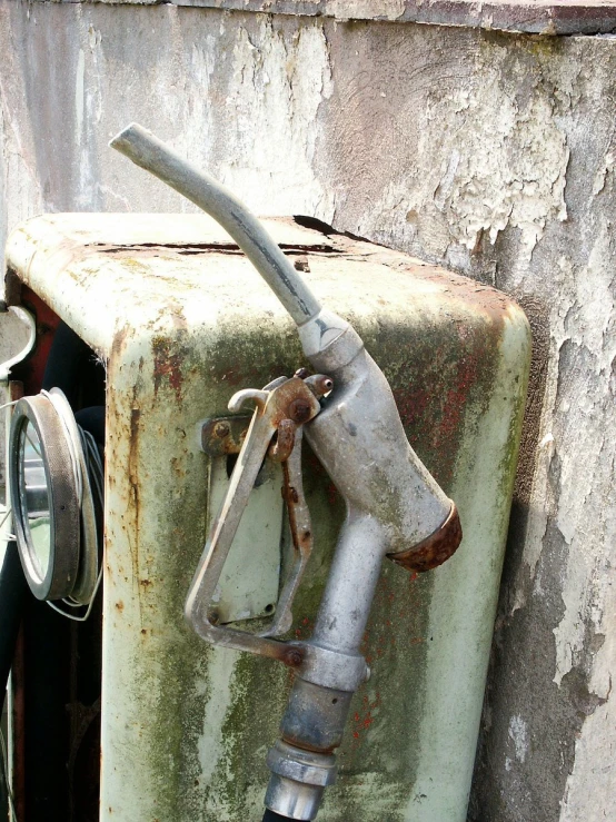 an old gas pump sits on top of an old gas tank