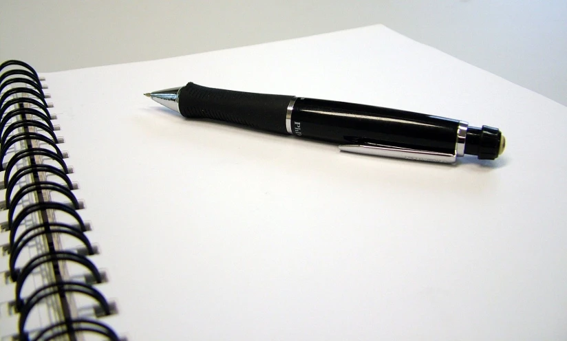 a pen sitting on top of a white notepad