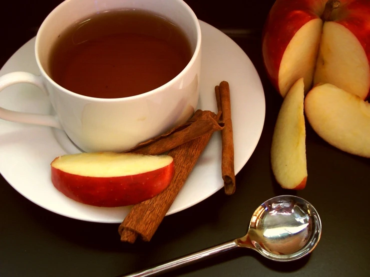 apple slices, cinnamon sticks, and a cup of  chocolate