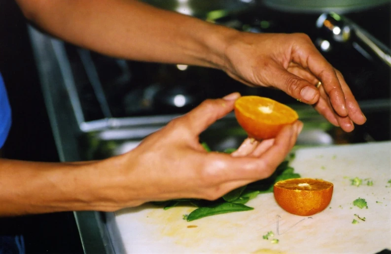 the man is peeling the orange slices on the table