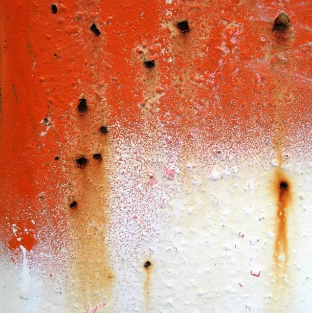 a rusted orange and white wall that appears to have been covered in rain