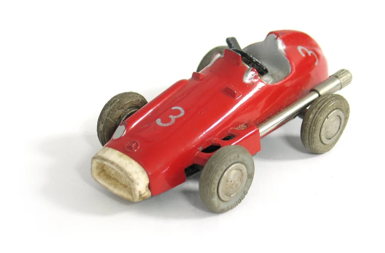 a small model of a race car sitting on the floor