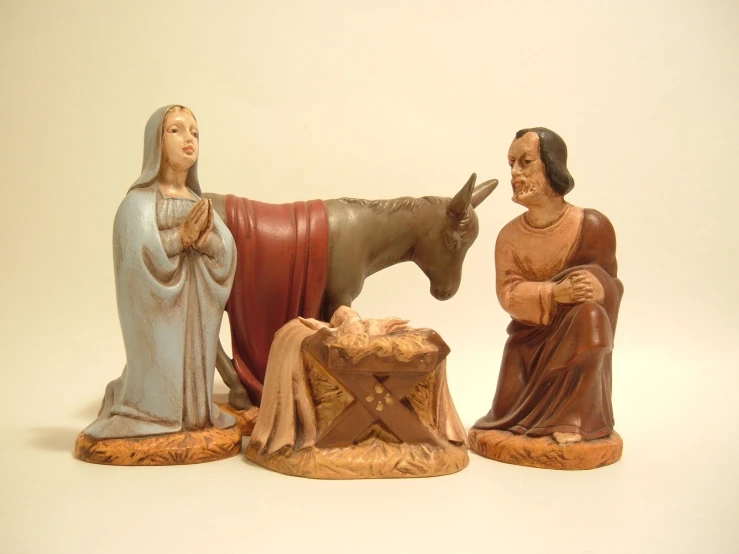 a statue of jesus, a statue of the infant and a donkey