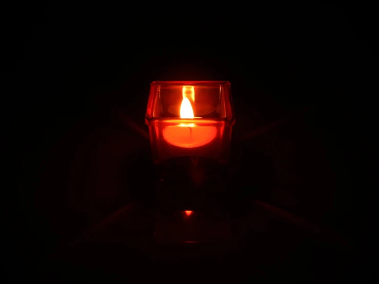 an image of a single candle glowing in the dark