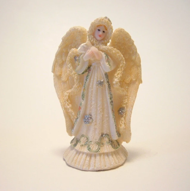 an angel figurine with white wings and a blue dress