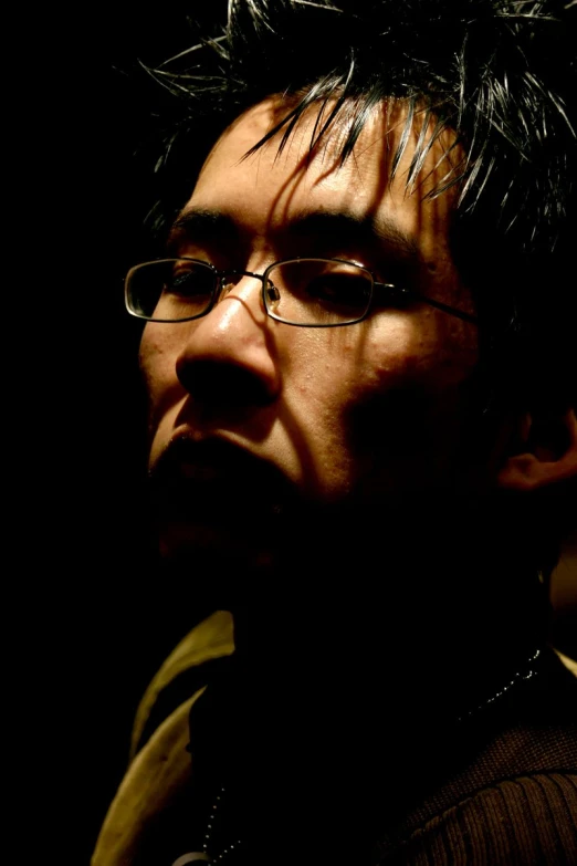 an asian man with dark hair and glasses is staring at soing
