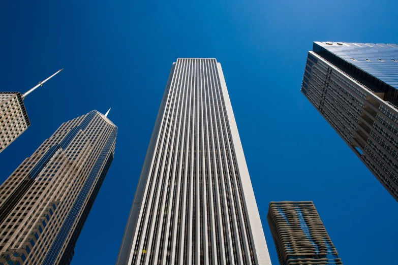 looking up at tall skyscrs and the top one on a clear day