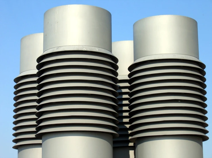 two stacks of gray stacked metal objects against a blue sky