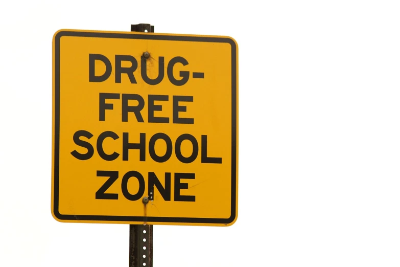 an orange sign reads drug - free school zone