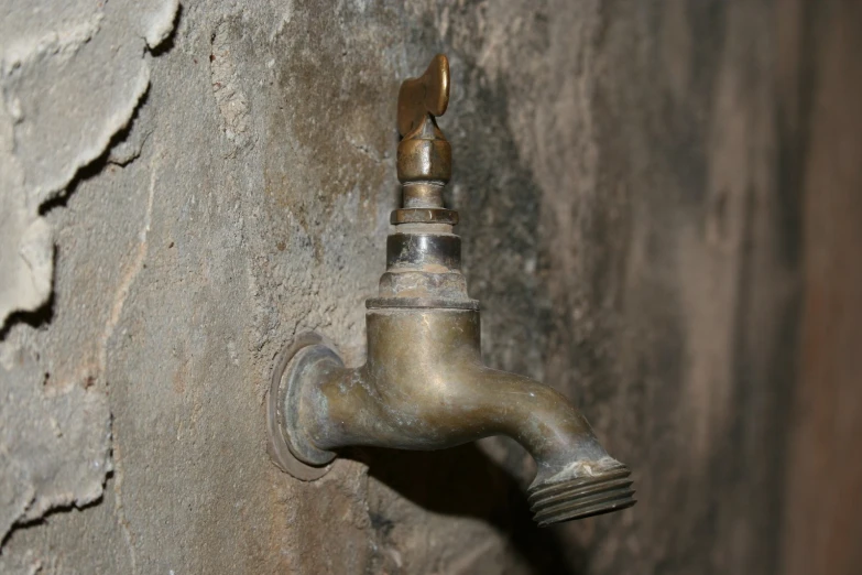 a faucet is shown against the concrete wall