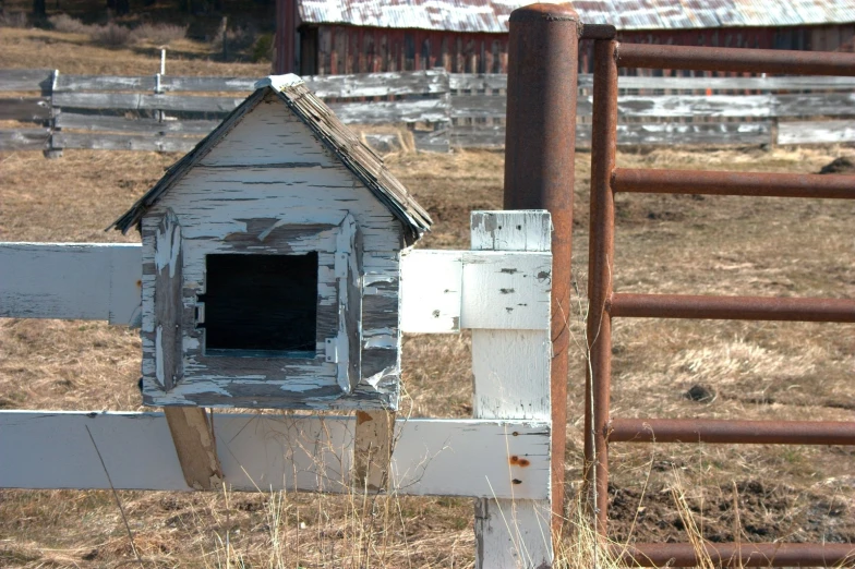 an old building sits behind a fence and gate