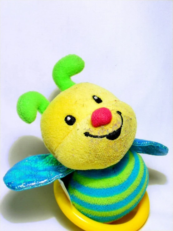 a yellow and green stuffed animal with a red nose