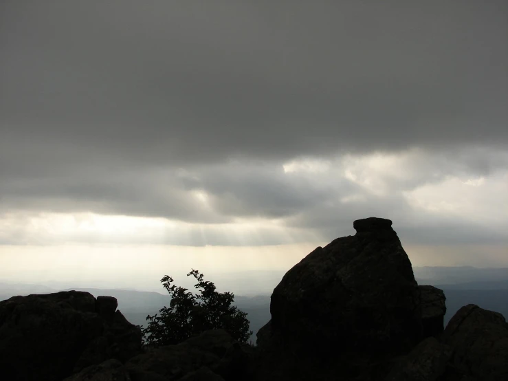 a rock formation with dark clouds in the background