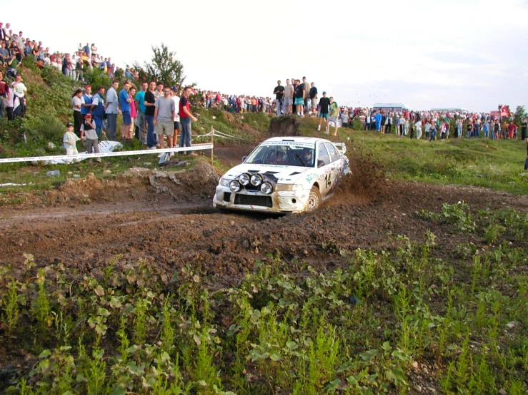 a white vehicle traveling up the dirt road