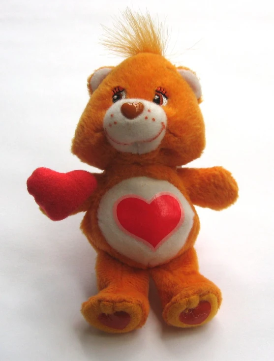 a brown teddy bear holding a heart toy