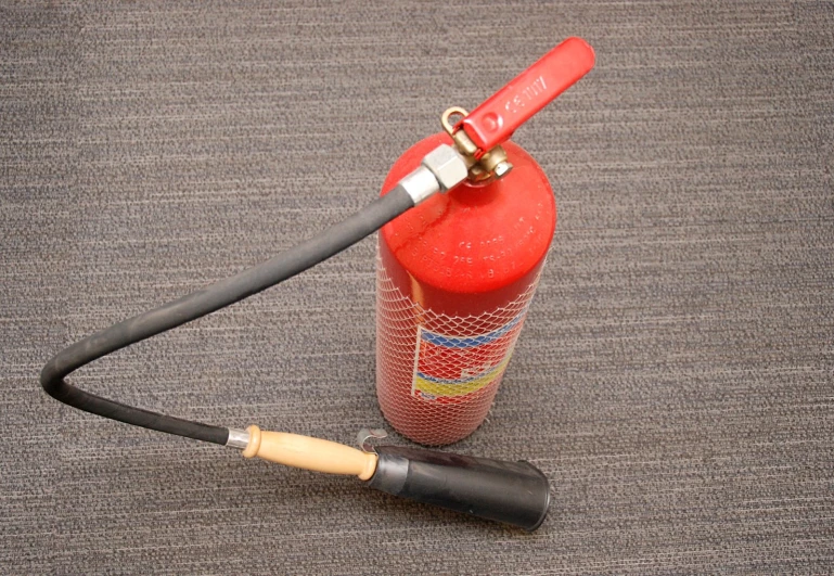 a hose attached to an orange and black fire extinguisher