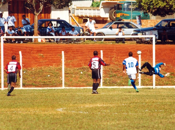 a group of soccer players standing around a soccer goal