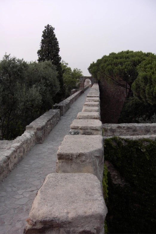 several stone benches are on a long, curved sidewalk