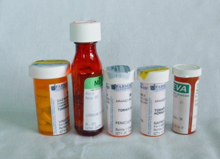 several prescription bottles are lined up on a bed