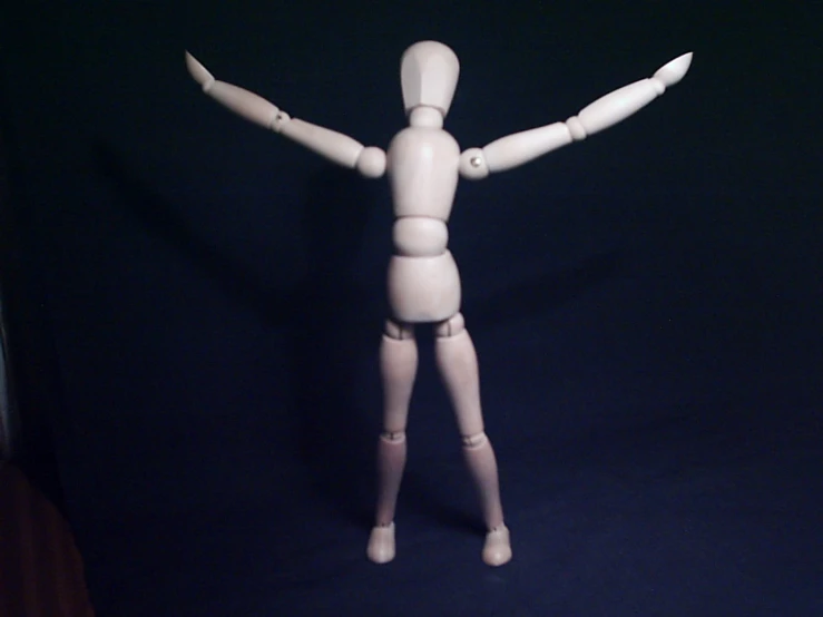 a toy standing on the ground with his arms spread wide