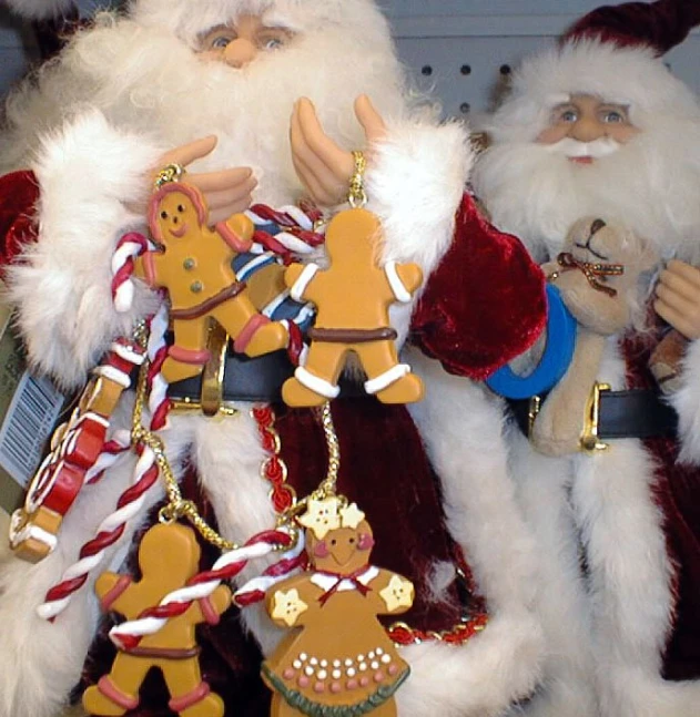two santa claus ornaments made of gingerbread cutouts