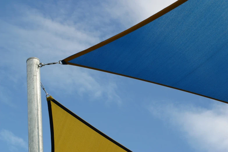 a blue and yellow triangle shaped cloth covering a pole