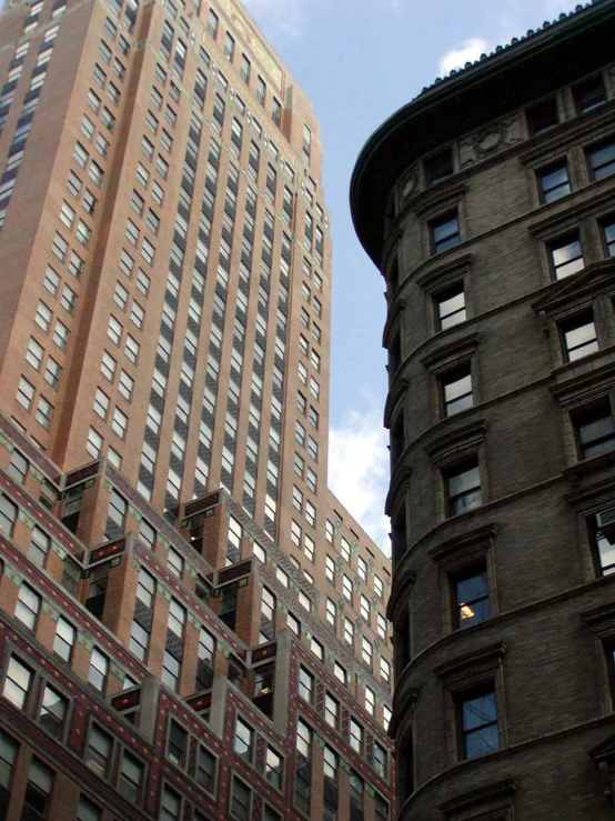 large brown buildings against a blue sky with clouds