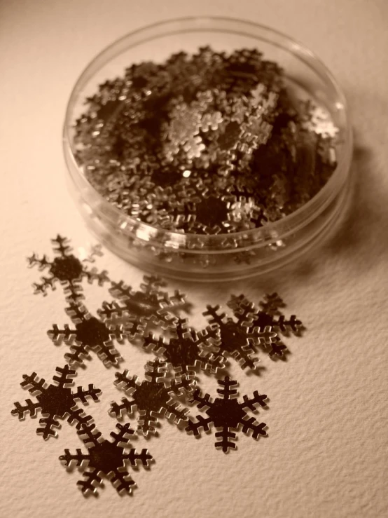 a glass bowl filled with silver glitter snowflakes