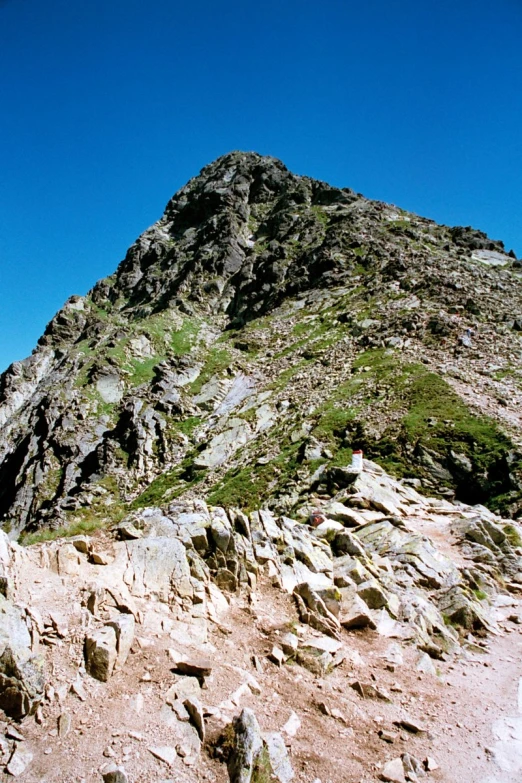 a very tall rocky mountain peak on a sunny day