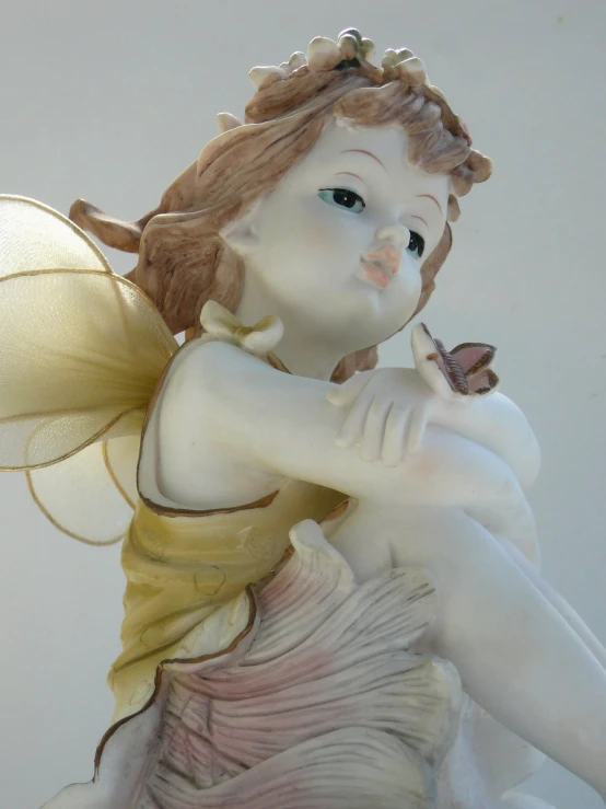 a figurine with a flower on its hand, holding a erfly