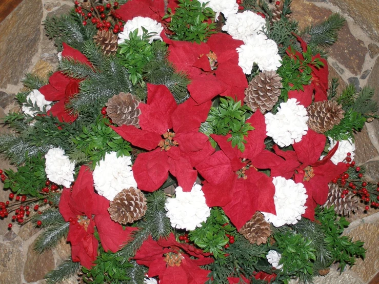 christmas decorations with poinsettis and pine cones decorate a circle