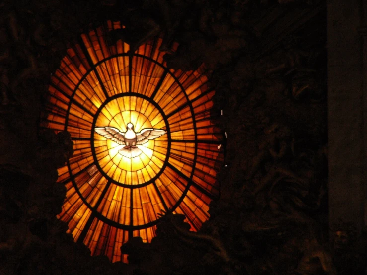 the stained glass window is depicting a bee with an orange yellow background